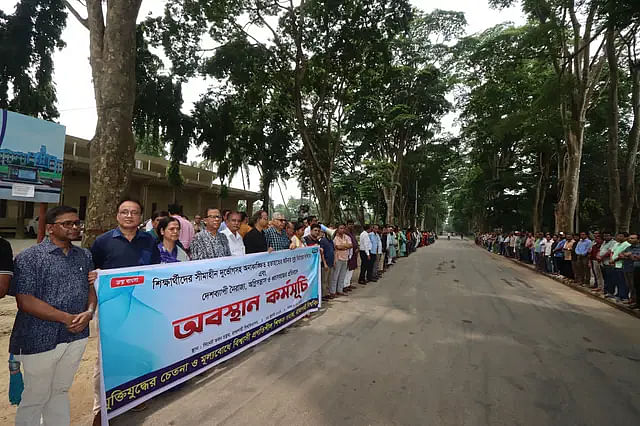 Progressive teachers hold a sit-in on the road near the senate bhaban adjacent to Paris Road in Rajshahi University at around 10:30am on Wednesday.